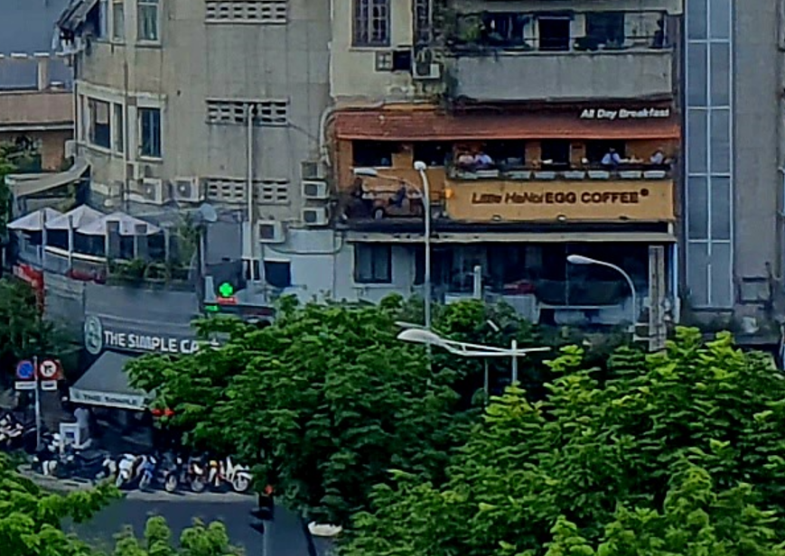 Nearby cafe signs including Little Hanoi Egg Coffee and The Simple Cafe